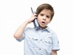 Here's an alt tag for the image: `Young boy talking on an old phone`