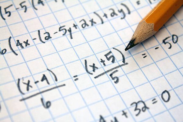 Handwritten math equations on grid paper.