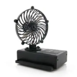 A black fan is sitting on top of the table.