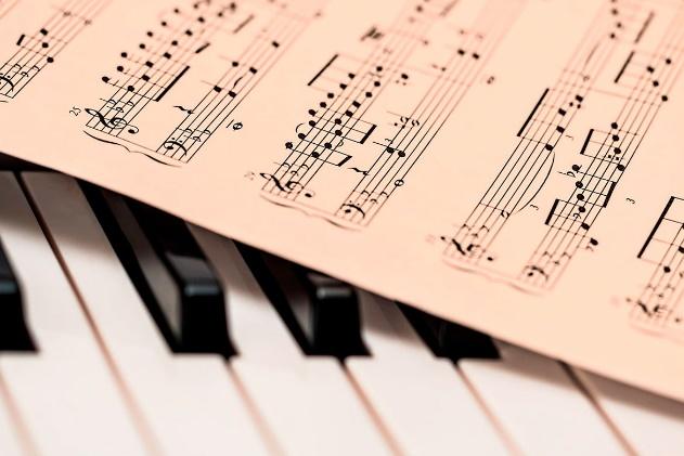 A close up of the piano keys and music sheet