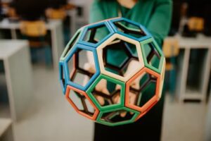 Colorful geometric structure held in hands.